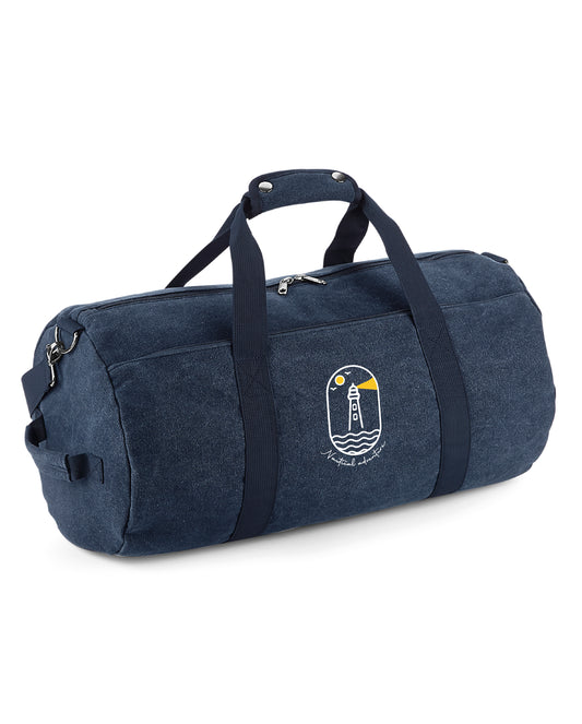 Travelbag with a logo of a lighthouse next to the ocean shining in the dark as a symbol for surfers, sailors and watersporters