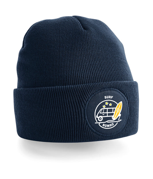 Beanie with a Logo of a surf camper van at the beach. A surf board next to the van